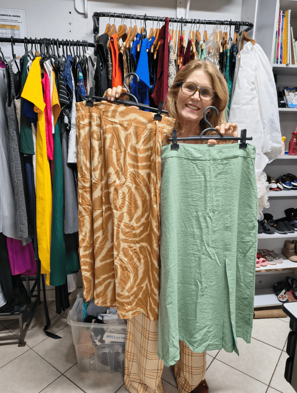 Roupas femininas em cabides no Bazar da ABEAS, Vitória/ES